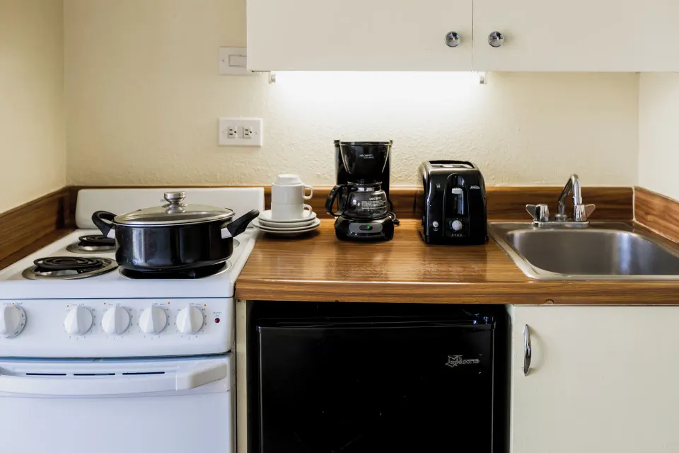 Close-up of the kitchenette counter and appliances in a Sky View Two room at Ohia Waikiki Studio Suites.