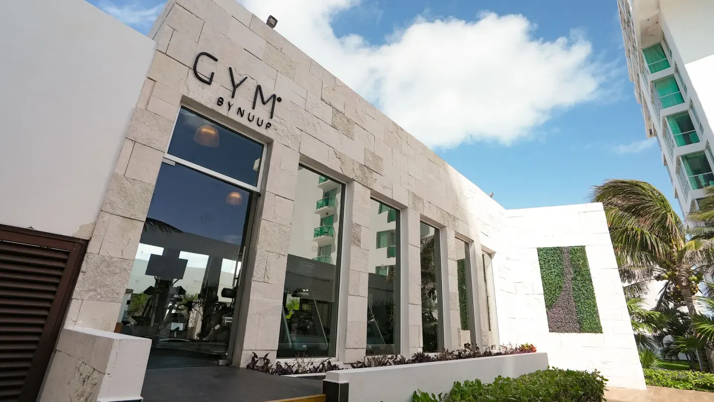 Gym exterior with visible signage and tall windows at Oleo Cancun Playa Resort.