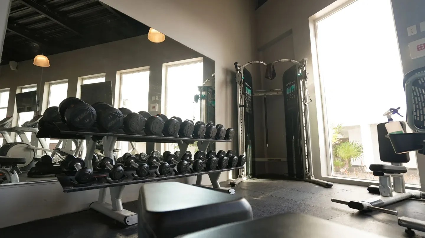 Dumbbell rack and strength equipment in the gym at Oleo Cancun Playa Resort.
