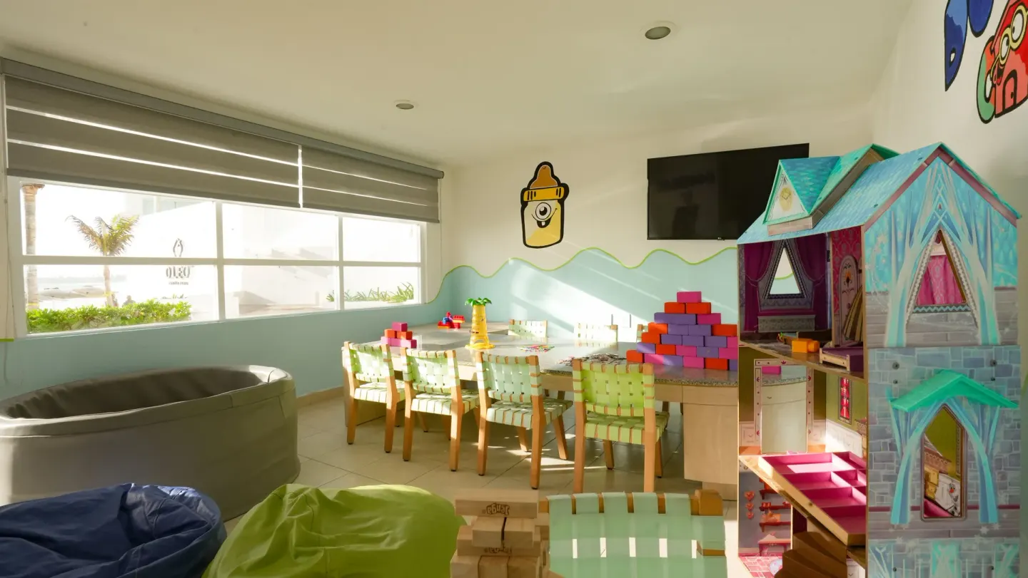 Kids club toy area with dollhouse and blocks at Oleo Cancun Playa Resort.