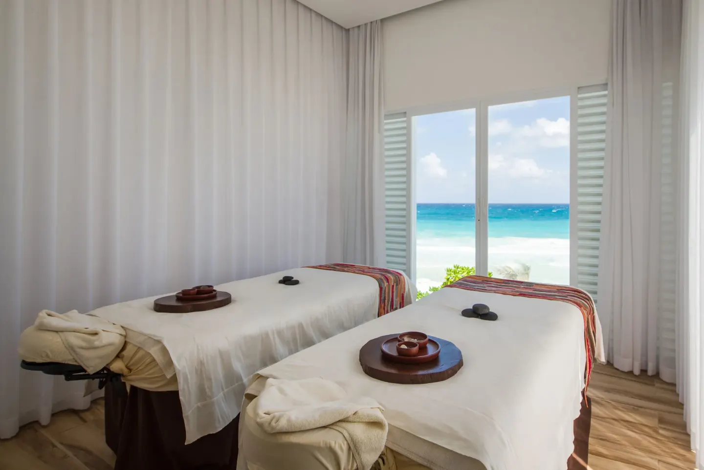 Two spa treatment tables overlook the ocean at Oleo Cancun Playa Resort.