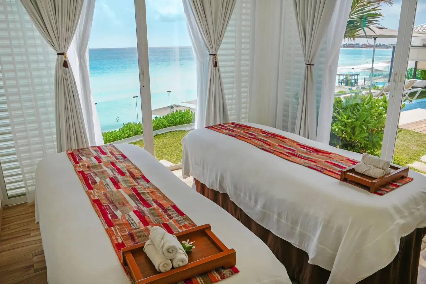 Two spa treatment beds facing the ocean at Oleo Cancun Playa Resort.