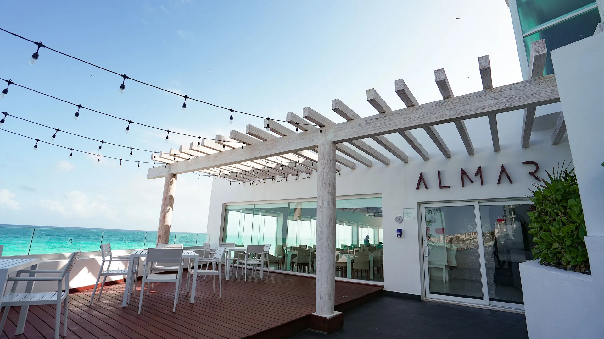 Almar terrace entrance with pergola seating and ocean view at Oleo Cancun Playa Resort.