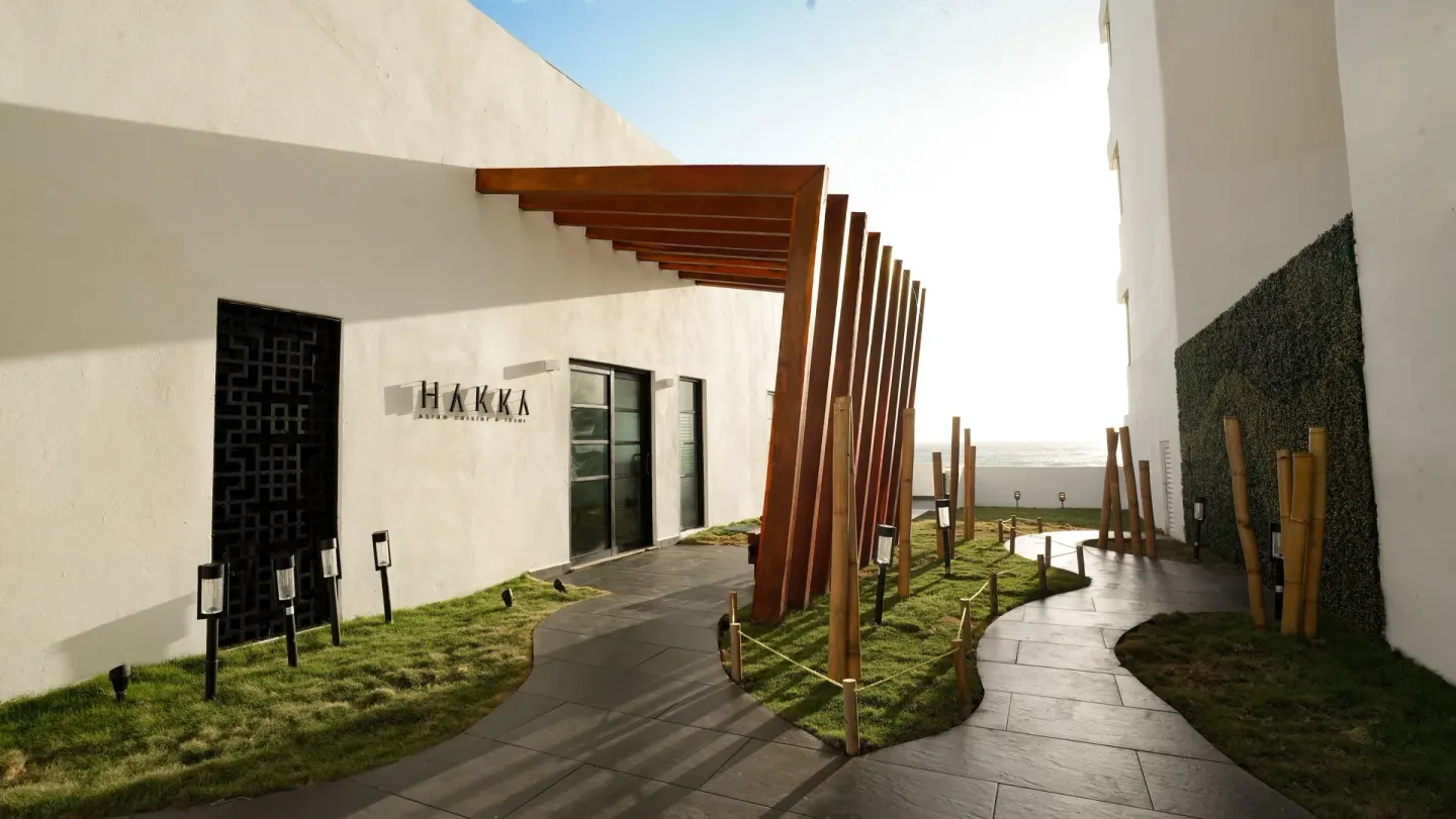 Hakka restaurant entrance walkway at Oleo Cancun Playa Resort with ocean beyond.