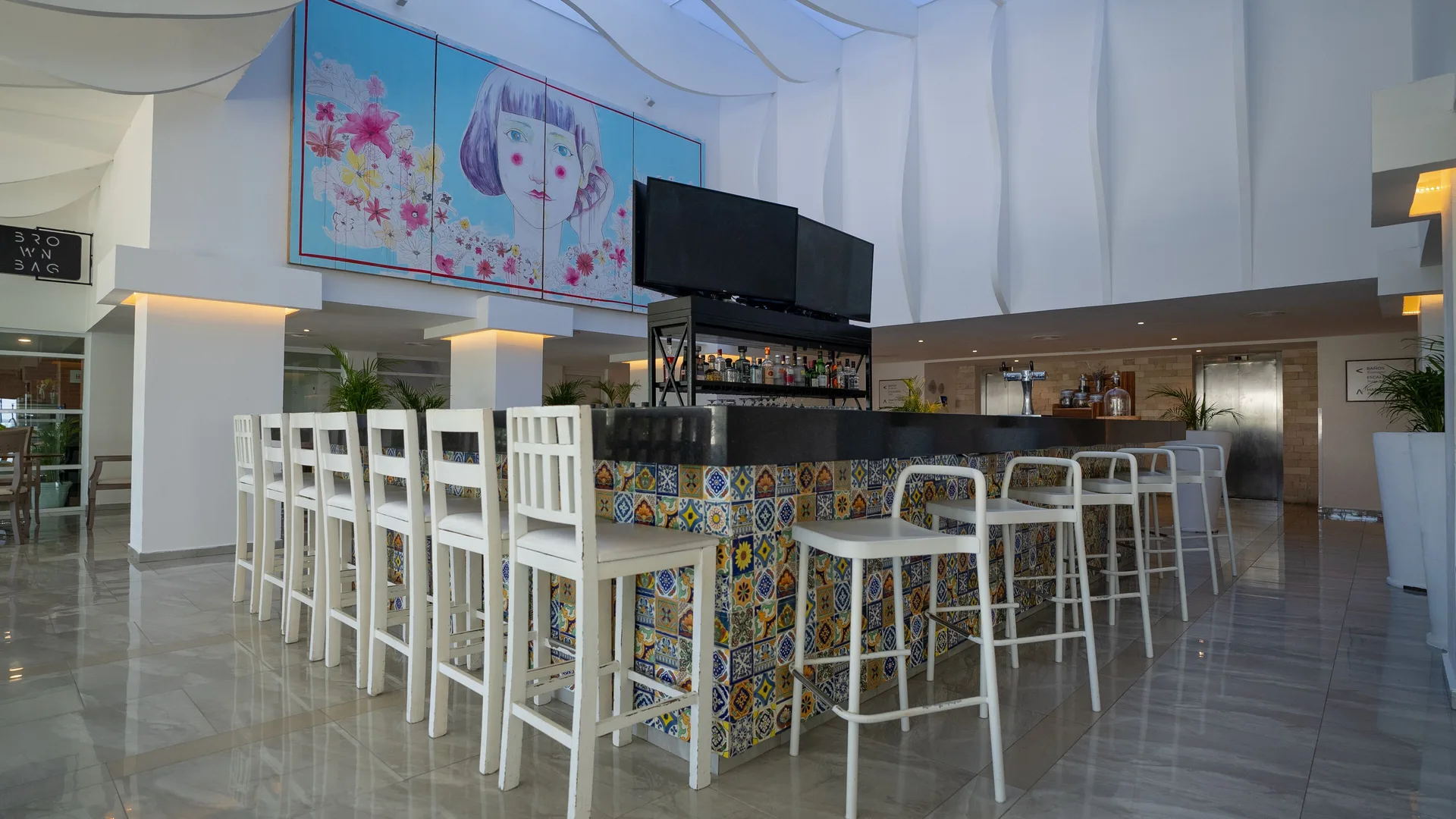 Lobby bar seating and colorful tiled counter at Oleo Cancun Playa Resort.