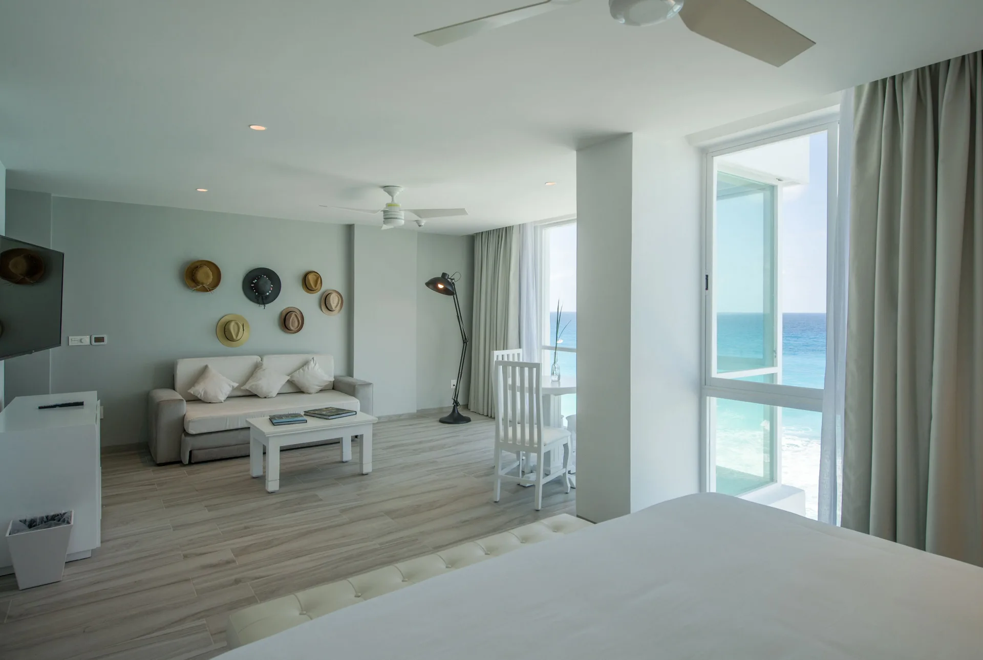 Inspira Junior Suite oceanfront living area and bed at Oleo Cancun Playa Resort.