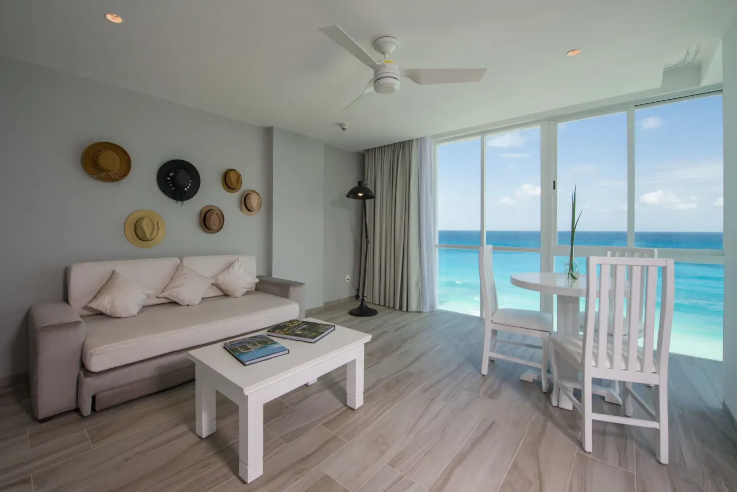 Inspira Junior Suite sitting area with oceanfront windows at Oleo Cancun Playa Resort.