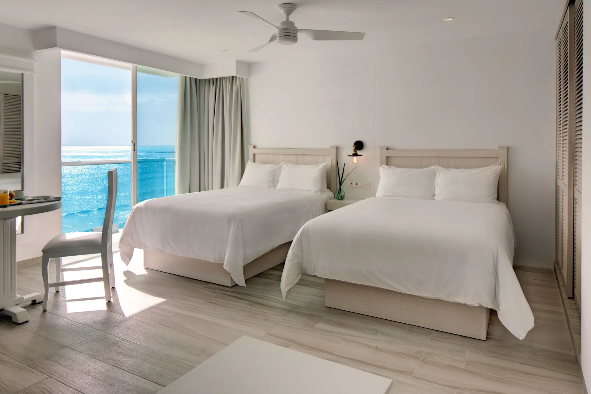 Inspira Superior Ocean View room with two beds and balcony at Oleo Cancun Playa Resort.