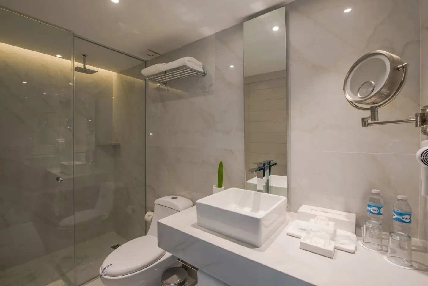 Junior Suite Sunset bathroom with glass shower and vanity at Oleo Cancun Playa Resort.