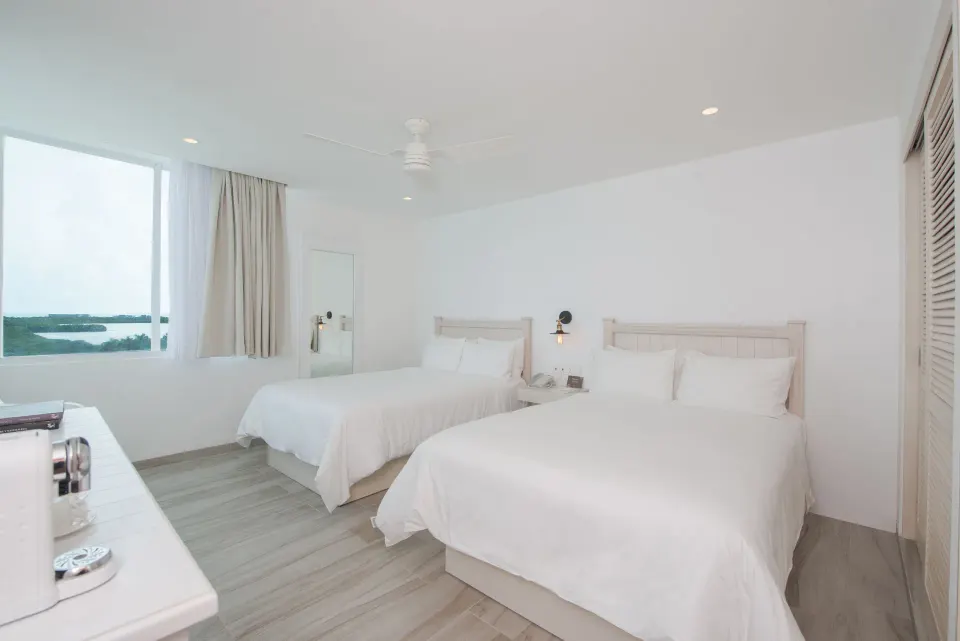 Standard Room with two white beds and window at Oleo Cancun Playa Resort.