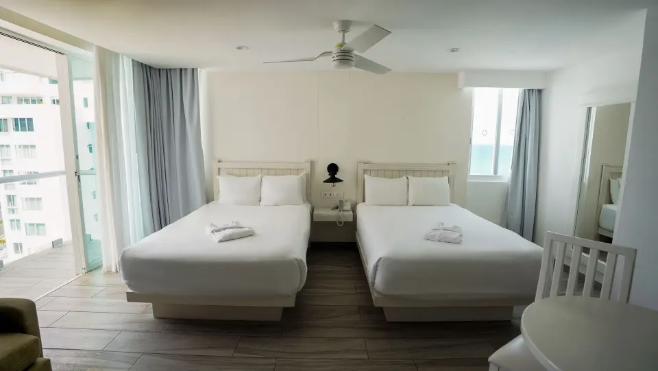 Superior Sunset room with two double beds and balcony at Oleo Cancun Playa Resort.