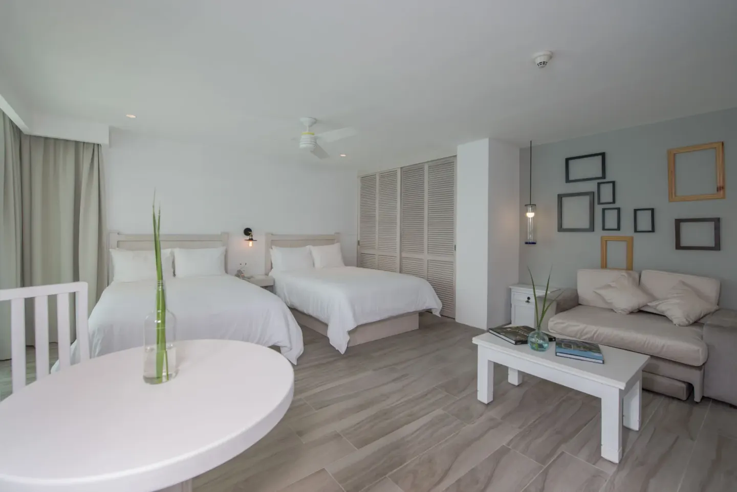 Superior Sunset room with two double beds, sofa, and round table at Oleo Cancun Playa Resort.