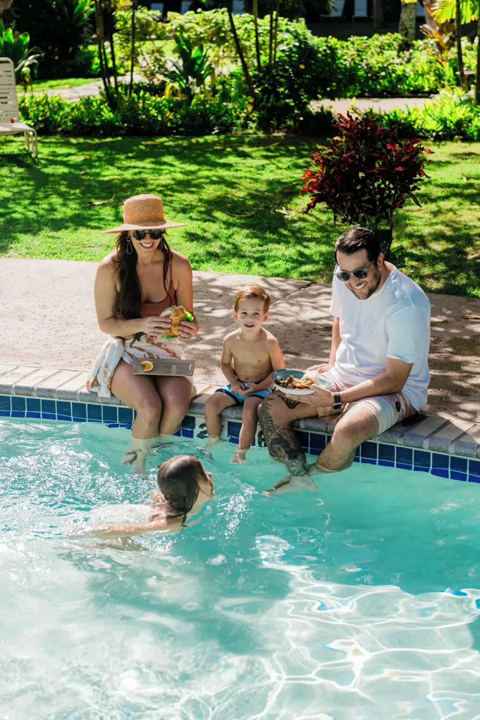 Family sitting at the pool edge with snacks at Outrigger Kaanapali Beach Resort.