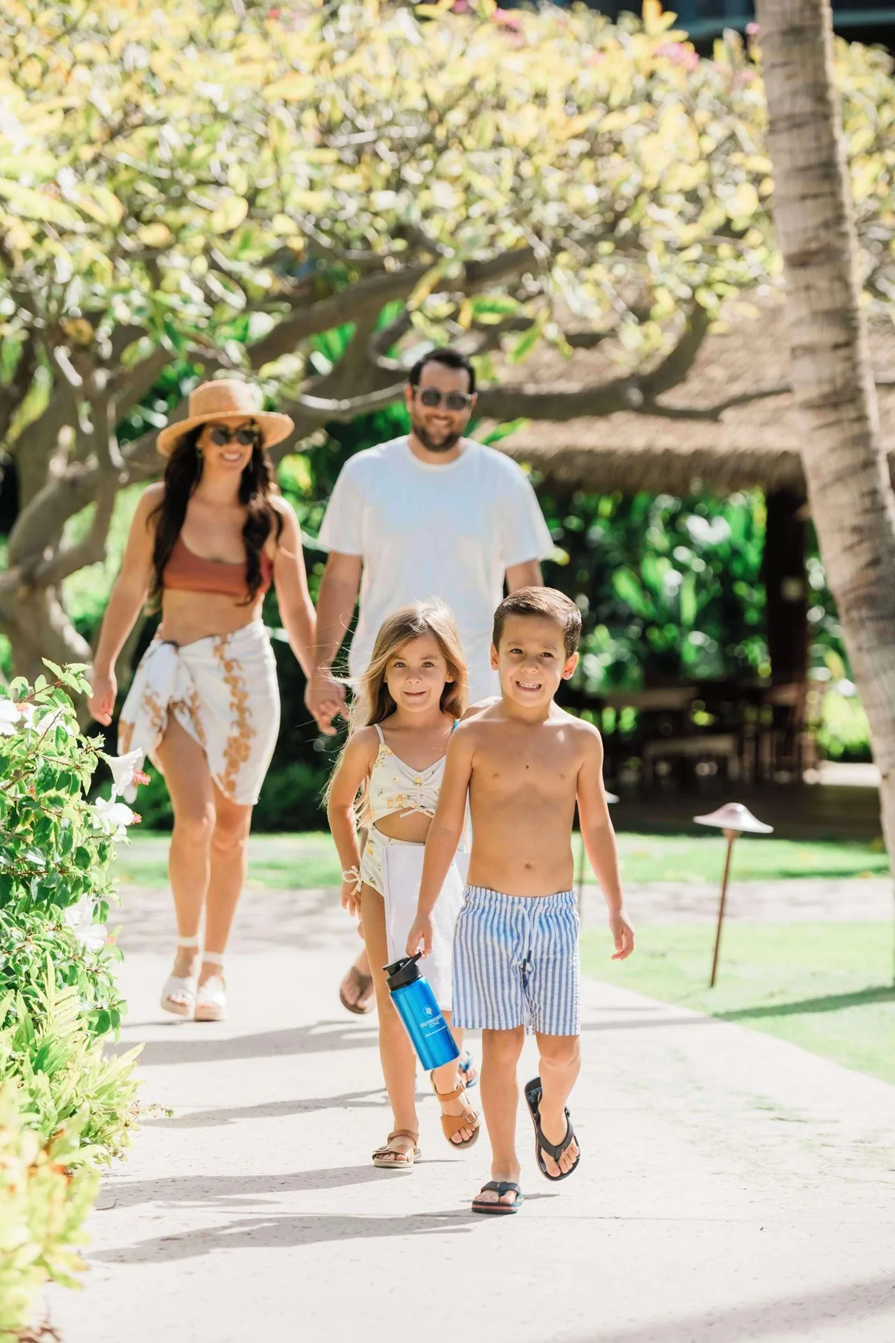 Family walking through tropical grounds at Outrigger Kaanapali Beach Resort.