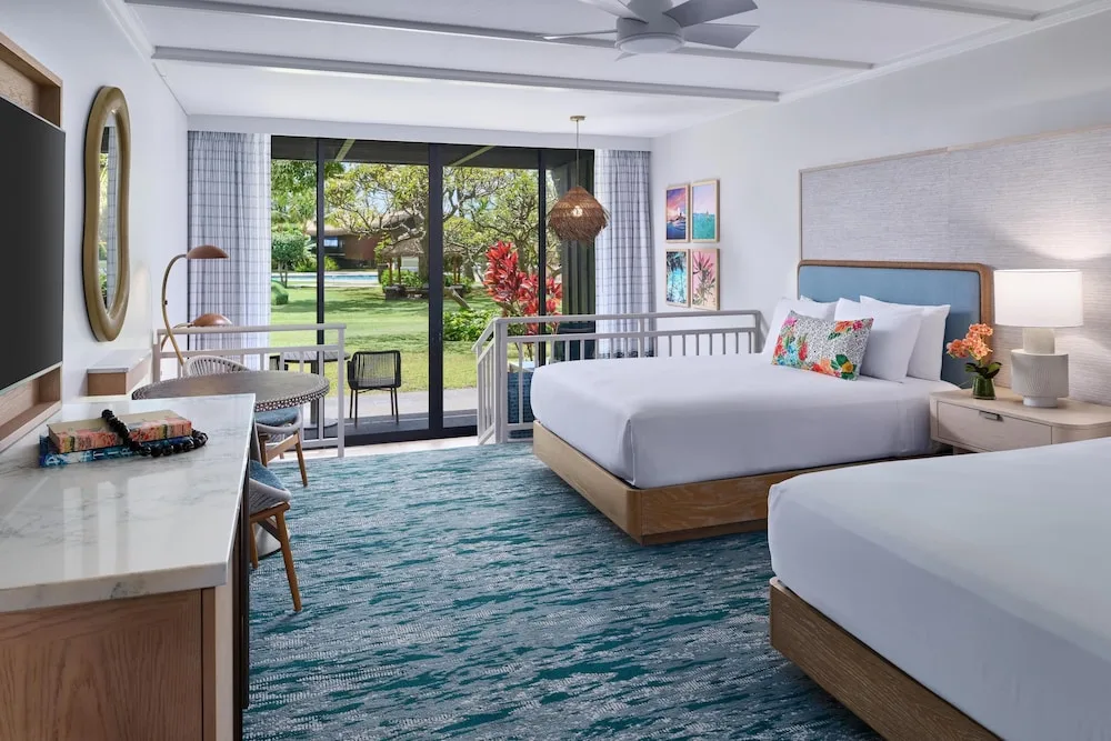 Ground-level guest room with two beds and lanai doors at Outrigger Kaanapali Beach Resort.