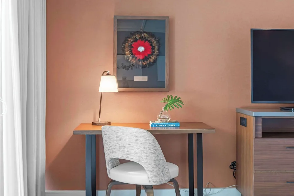 Guest room desk, chair, lamp, artwork, and TV at Outrigger Kaanapali Beach Resort.