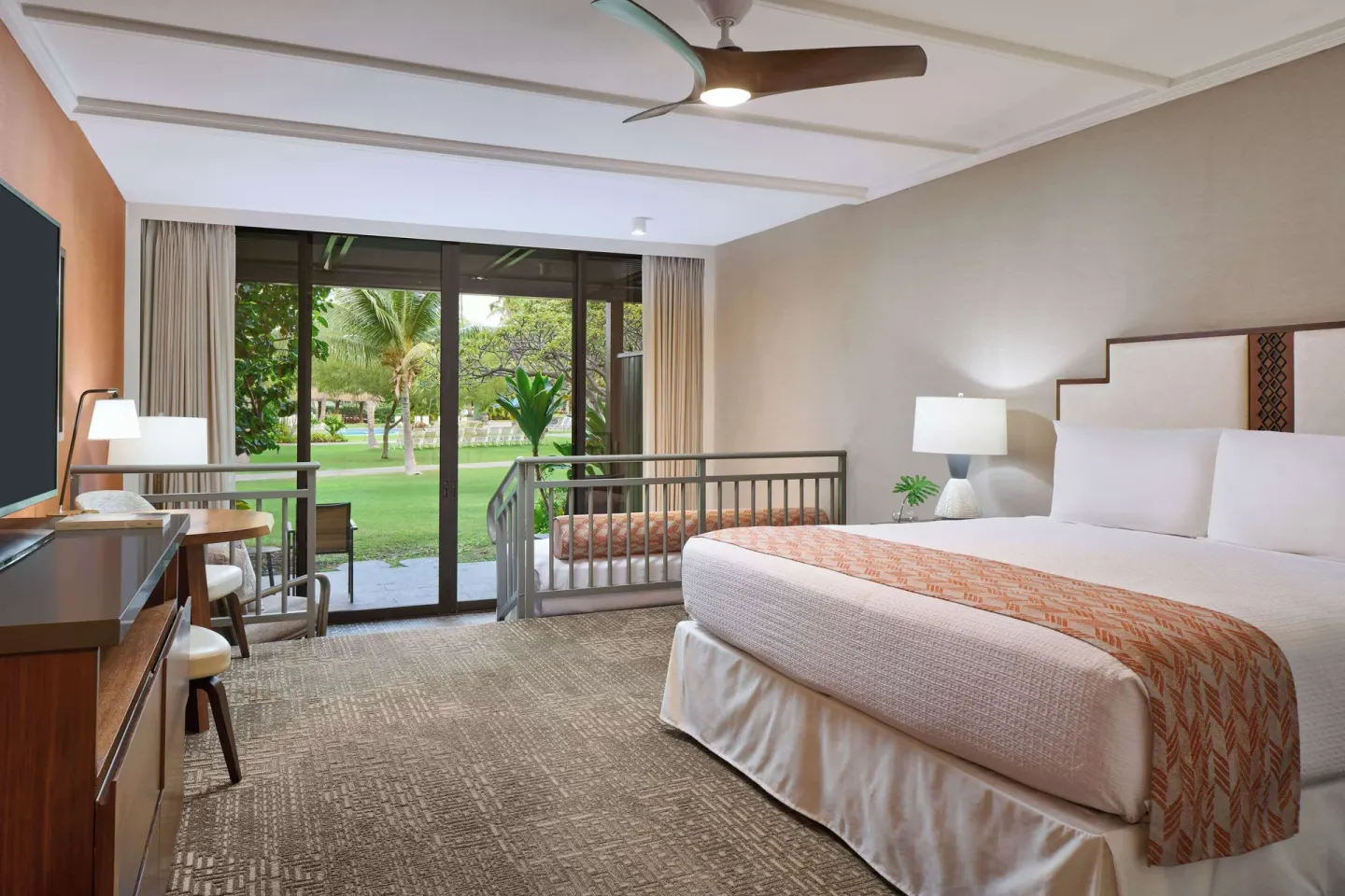 King bed guest room with ground-level patio and lawn at Outrigger Kaanapali Beach Resort.