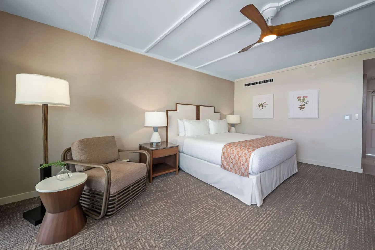 King guest room with lounge chair and floral wall art at Outrigger Kaanapali Beach Resort.