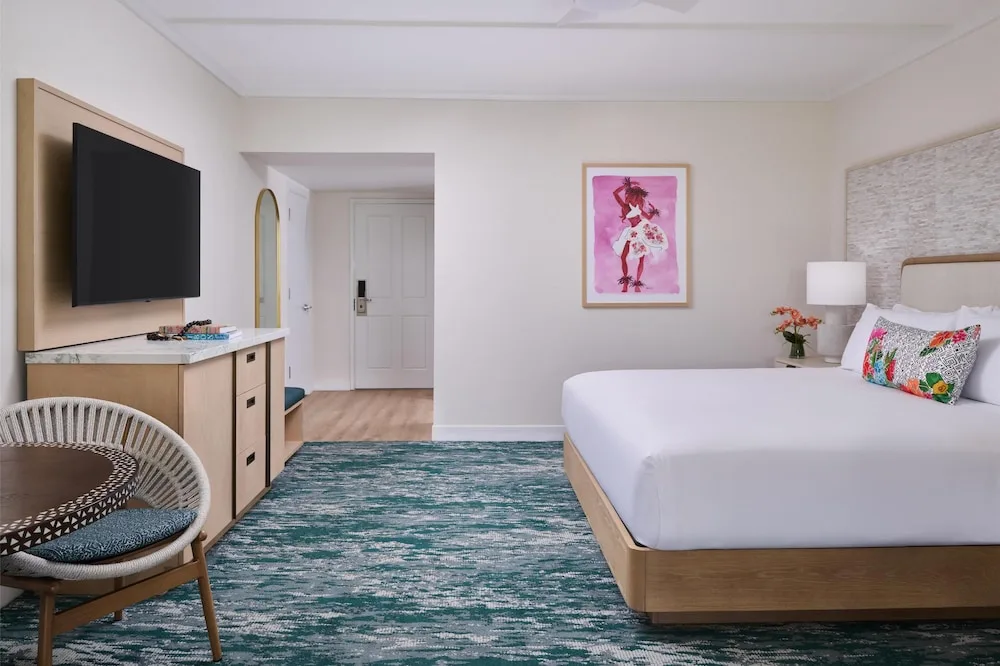 Guest room with one bed, dining chair and TV at Outrigger Kaanapali Beach Resort.