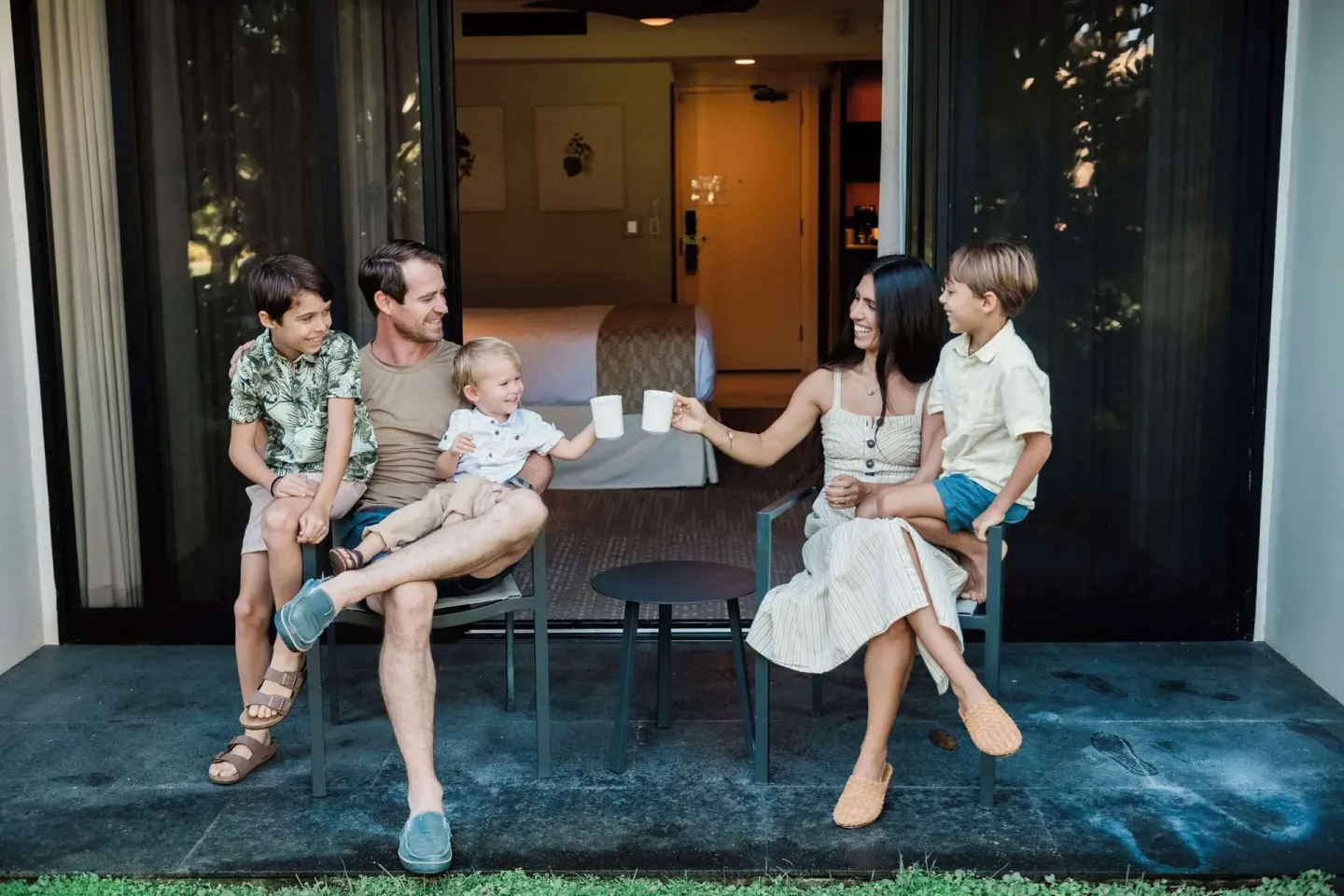 Family seated on a guest room patio at Outrigger Kaanapali Beach Resort.