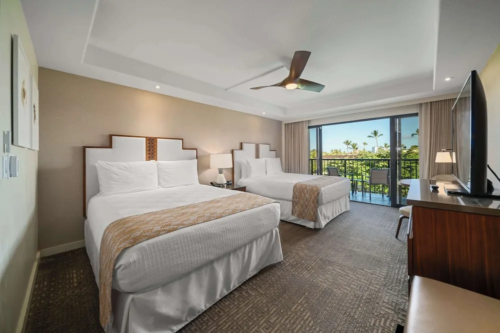 Two-queen guest room with balcony and treetop view at Outrigger Kaanapali Beach Resort.