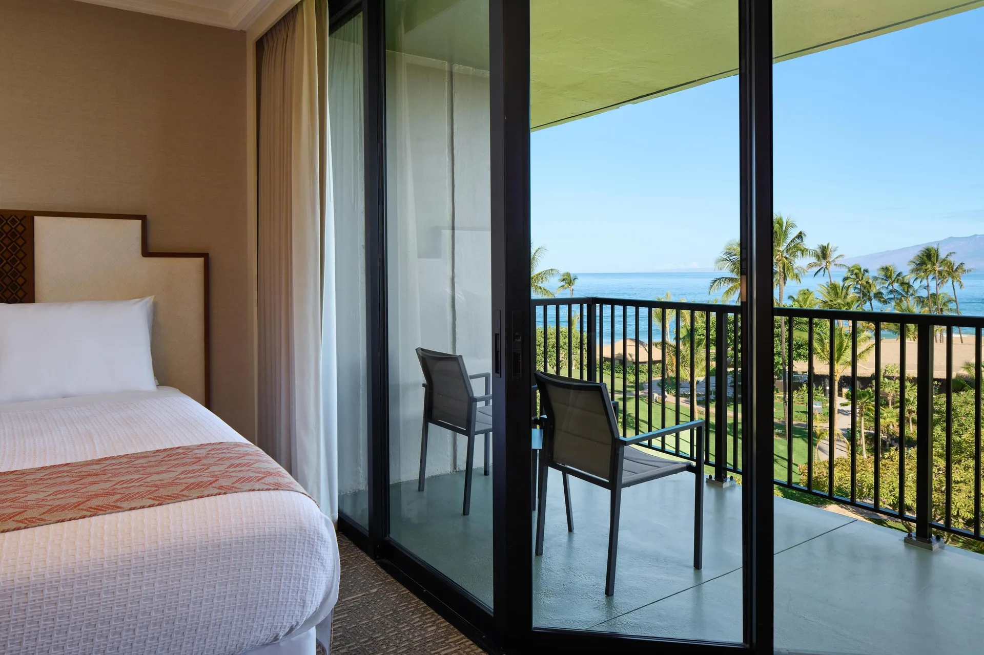 Premium Ocean View room bed and balcony at Outrigger Kaanapali Beach Resort.