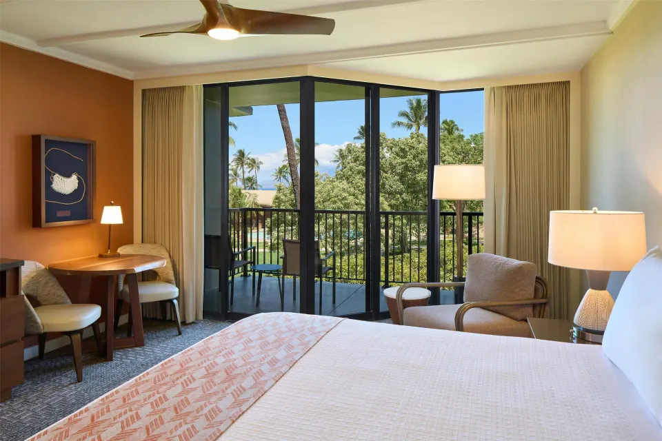 Premium Room king bed and balcony with partial ocean view at Outrigger Kaanapali Beach Resort.
