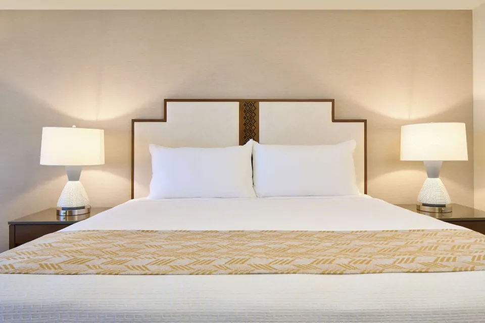 Premium Room king bed with bedside lamps at Outrigger Kaanapali Beach Resort.