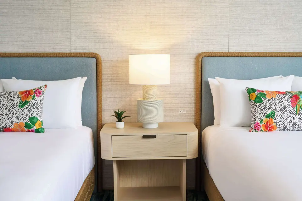 Two beds with a shared nightstand in a Signature Room at Outrigger Kaanapali Beach Resort.