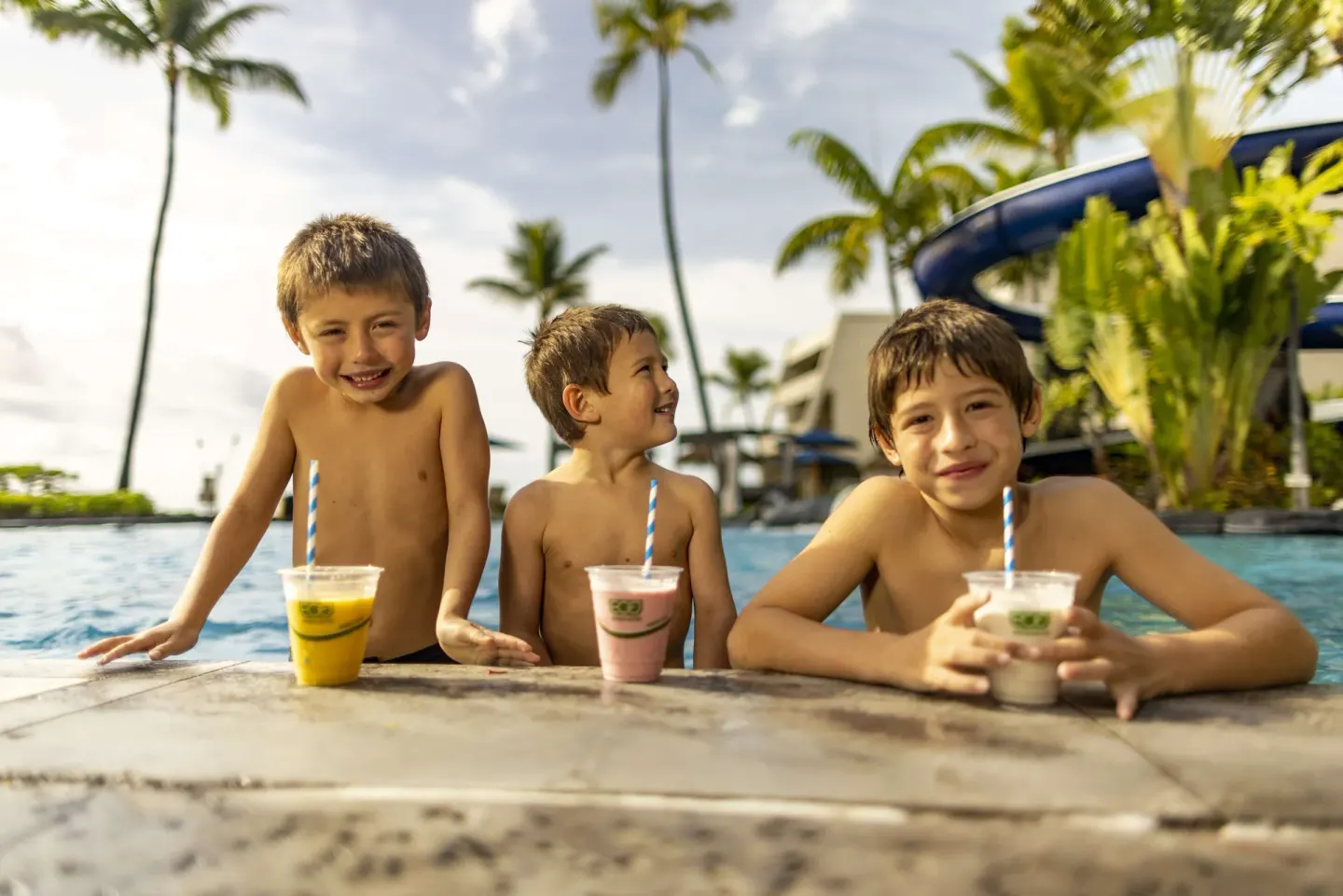 Children with drinks at the pool edge at Outrigger Kona Resort and Spa.