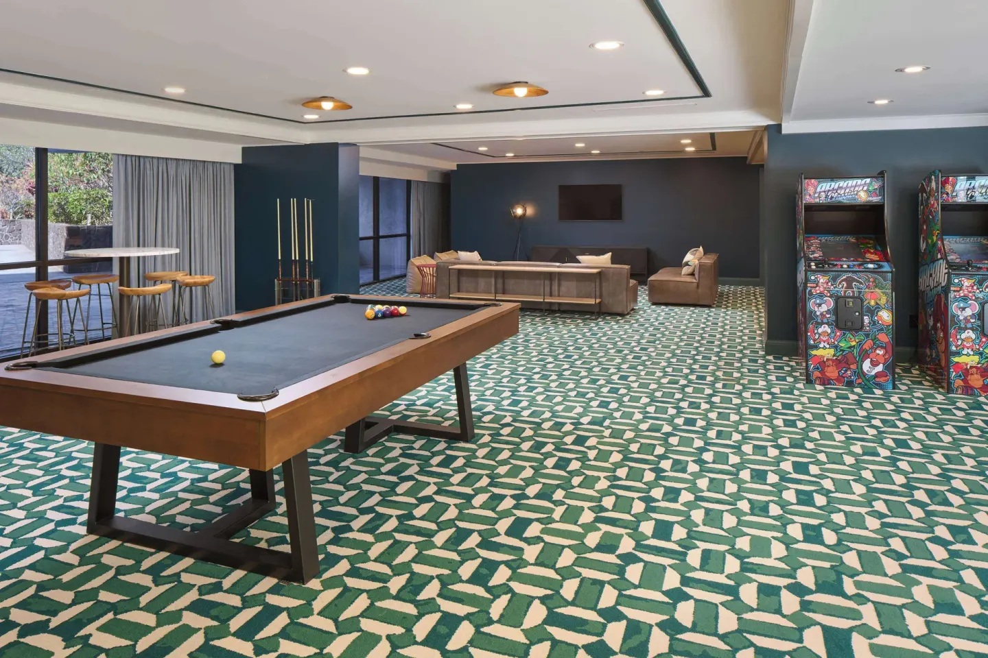 Game room with pool table, arcade games, and lounge seating at Outrigger Kona Resort and Spa.