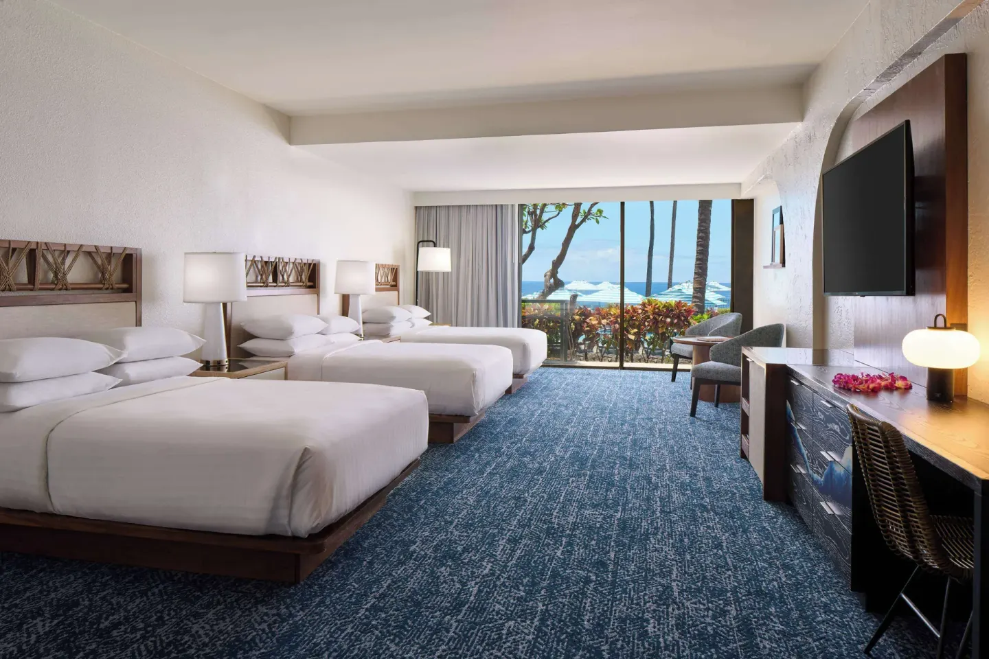 Guest room with two beds, balcony, and pool view at Outrigger Kona Resort and Spa.