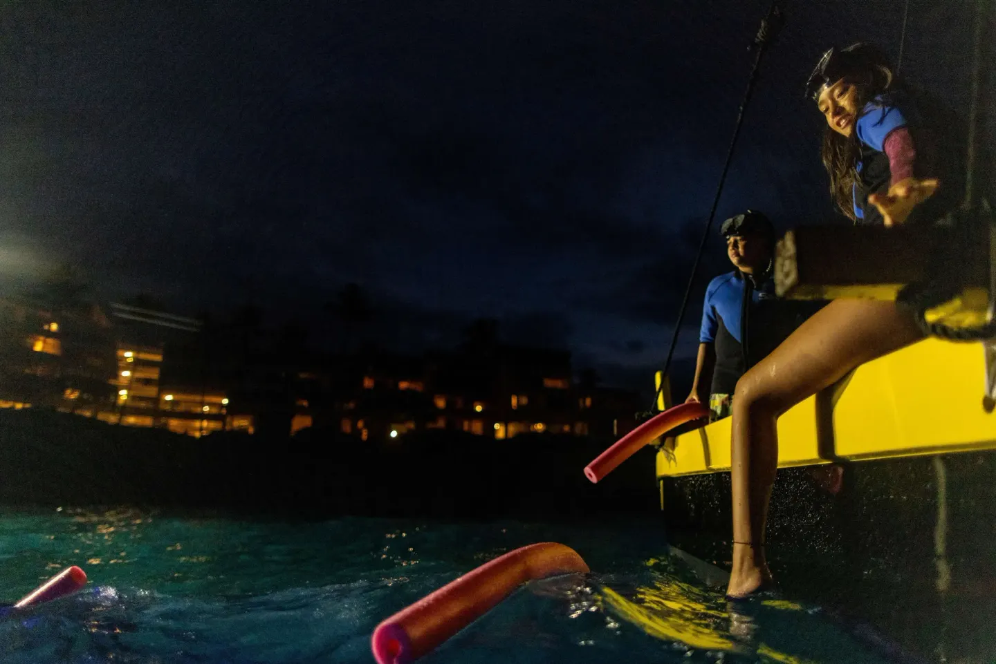 Night snorkel boat with guests entering the water at Outrigger Kona Resort and Spa.