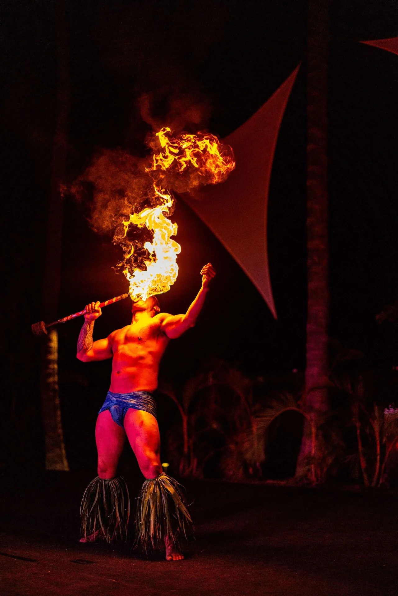 Fire performer holding a flaming torch at Outrigger Kona Resort and Spa.