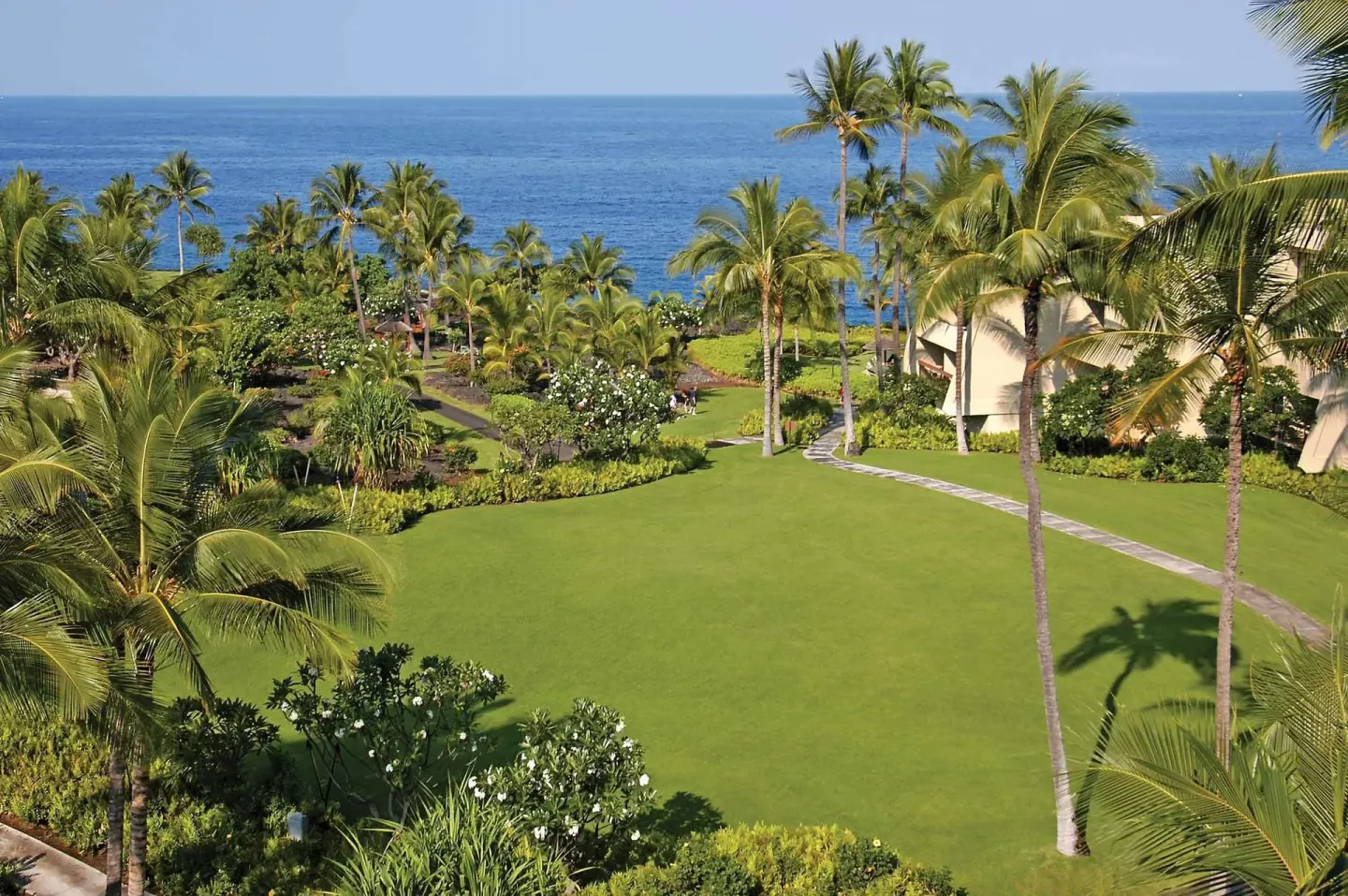 Oceanfront lawn with palm trees at Outrigger Kona Resort and Spa.