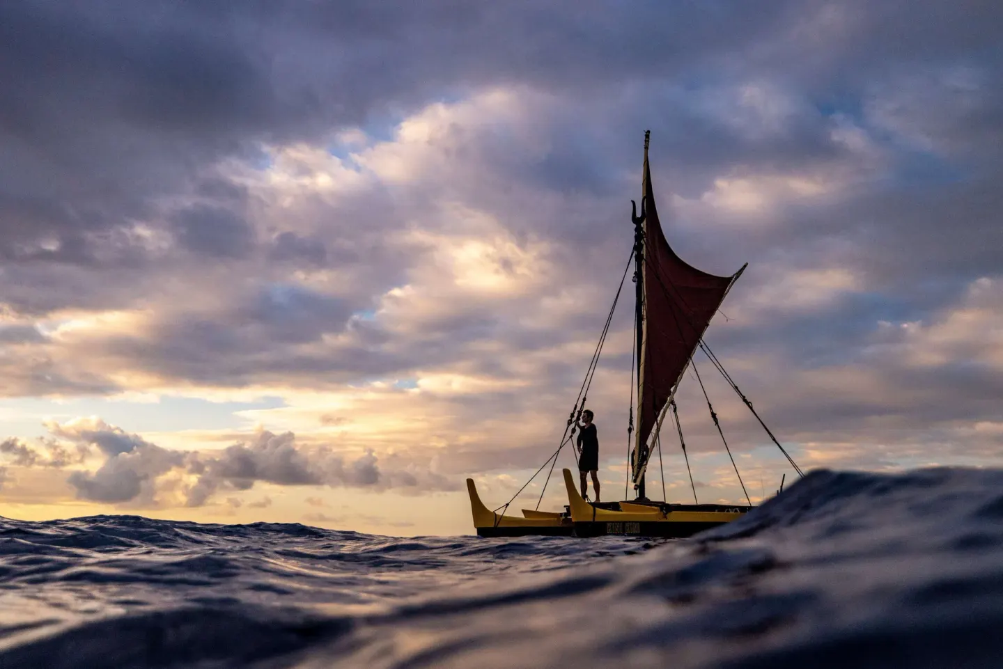 Sailing canoe on the ocean at sunset near Outrigger Kona Resort and Spa.