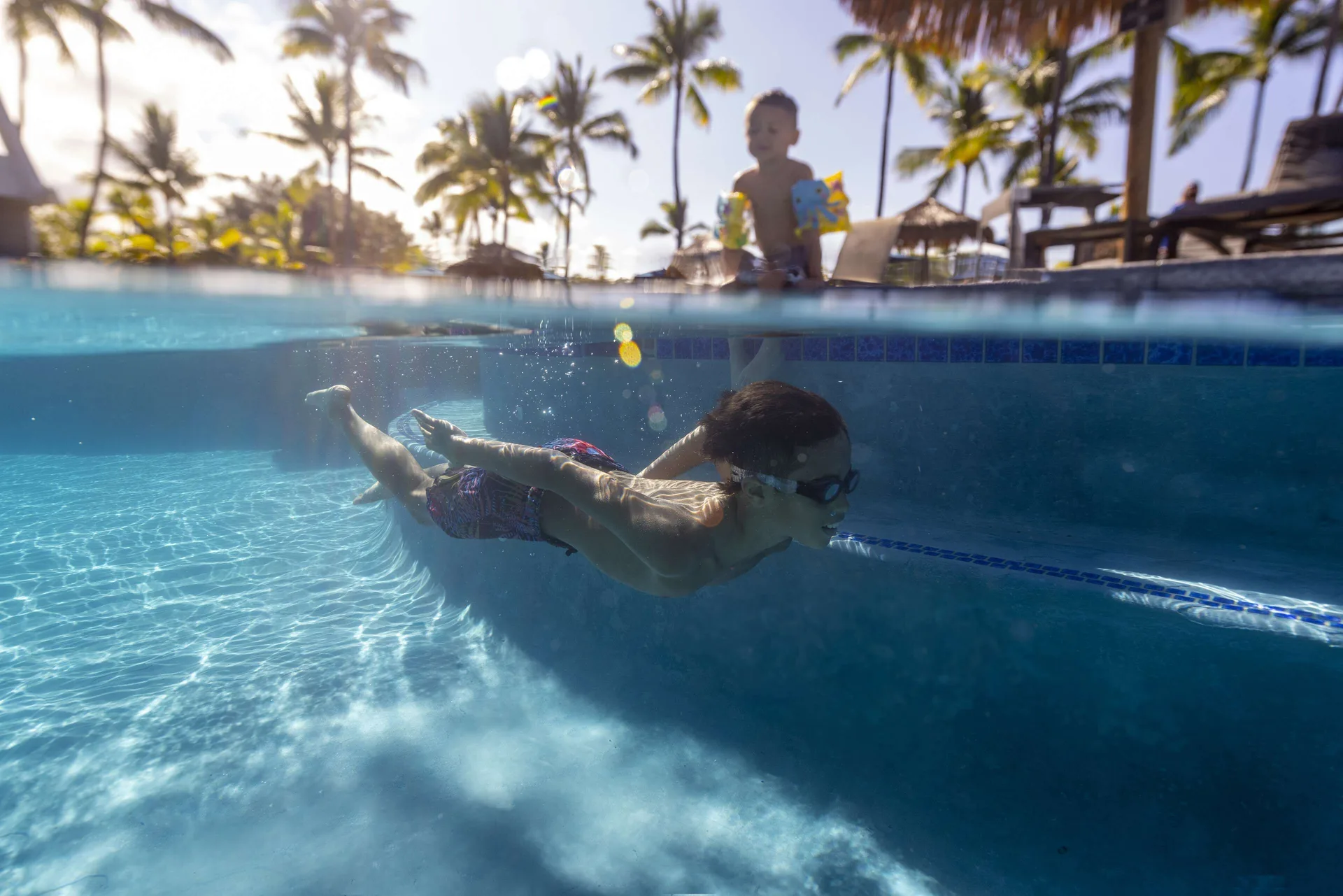A child swims underwater in the pool at Outrigger Kona Resort and Spa.