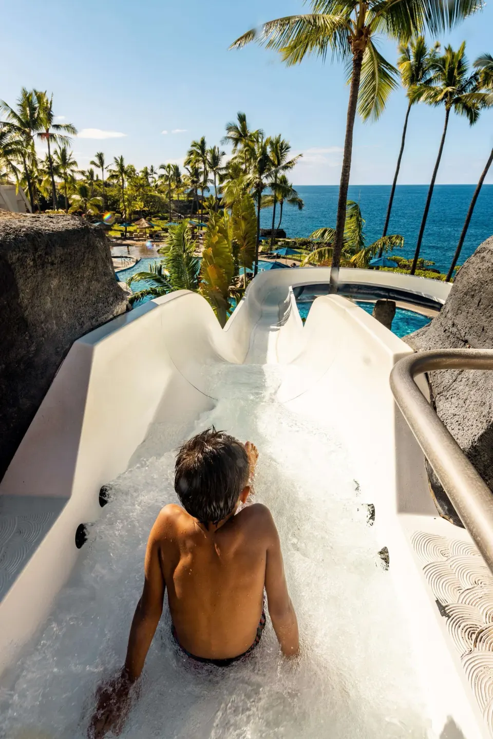 Child starts down the waterslide with ocean views at Outrigger Kona Resort and Spa.