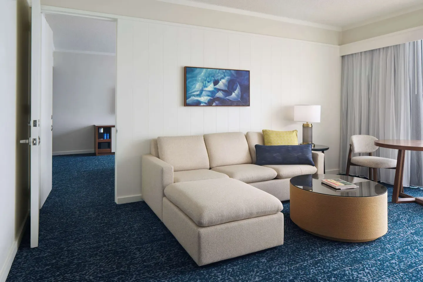 Club suite sitting room with sofa bed, coffee table and artwork at Outrigger Kona Resort and Spa.