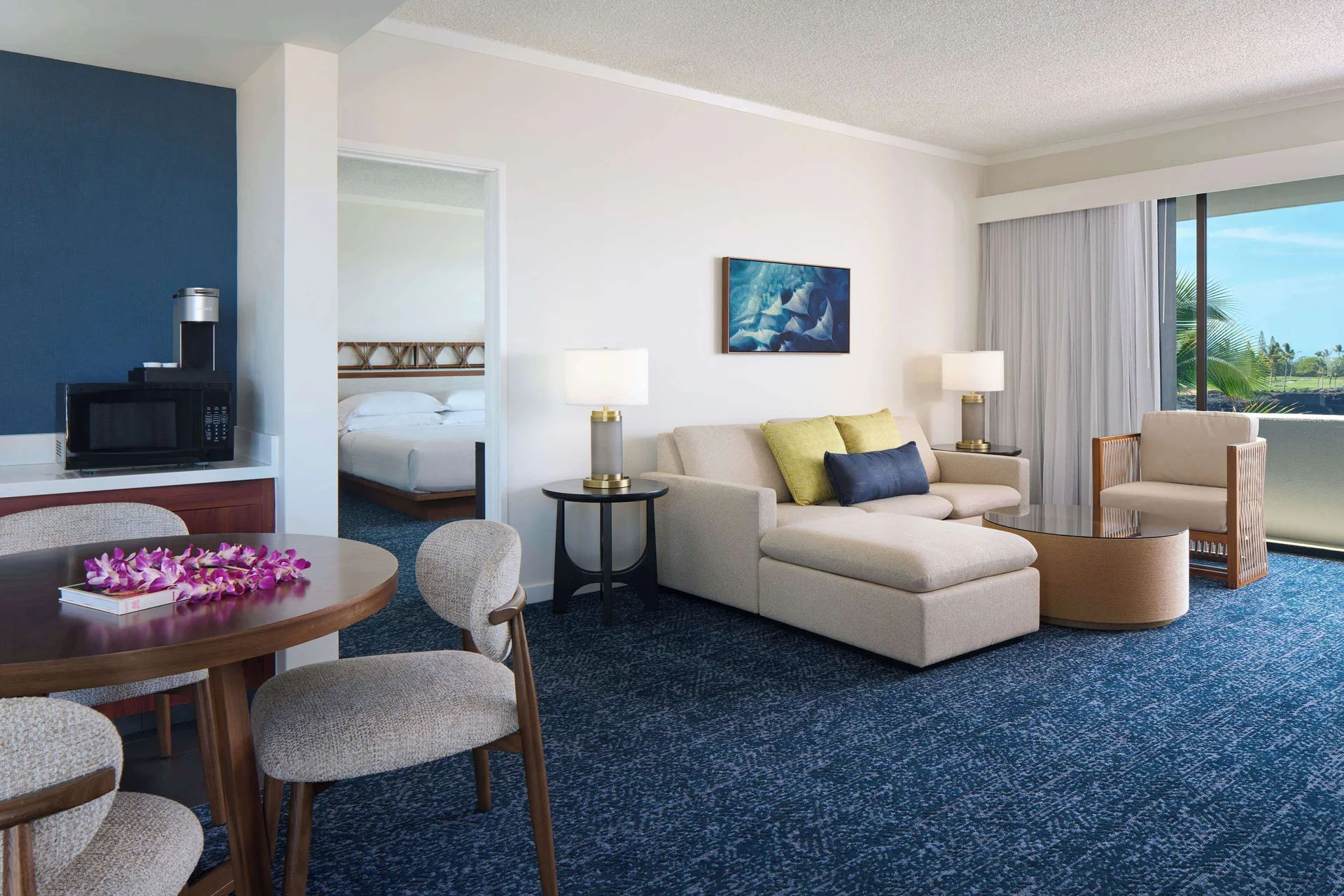 Deluxe Ocean Front Suite living area with dining table and sofa at Outrigger Kona Resort and Spa.