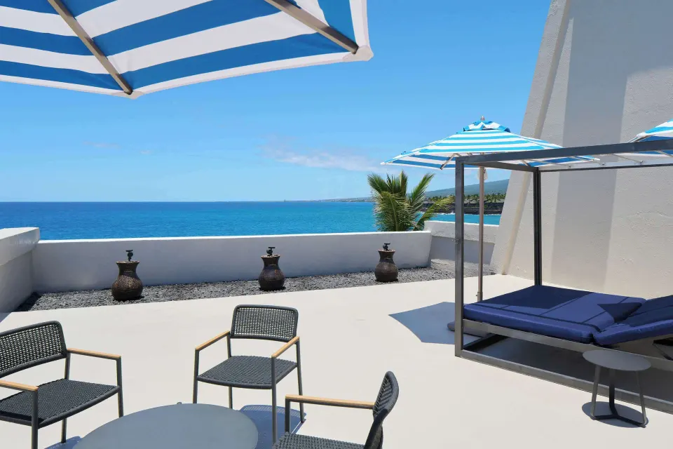Deluxe Ocean Front Suite terrace with lounge seating and ocean view at Outrigger Kona Resort and Spa.