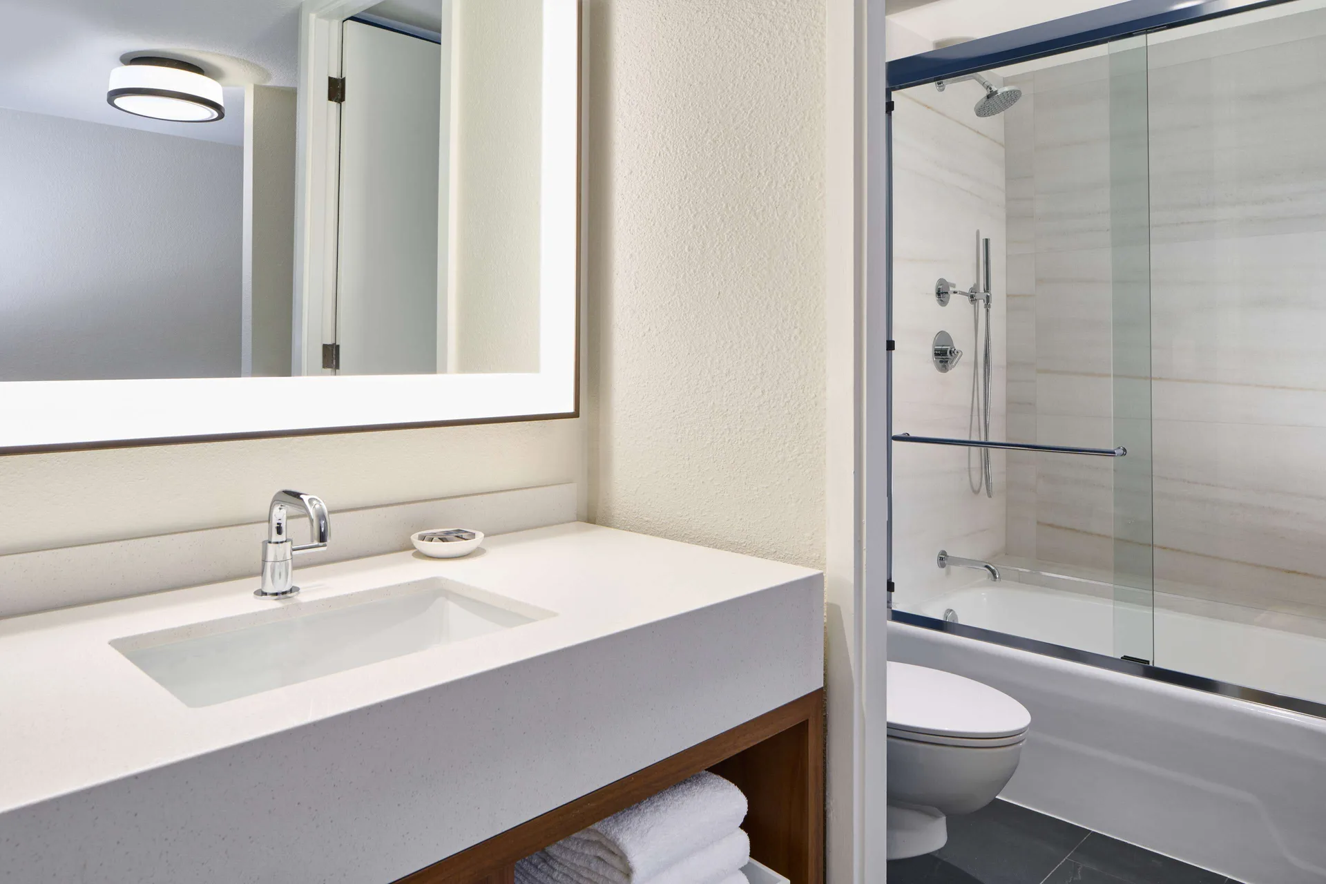 Guest room bathroom vanity and tub shower at Outrigger Kona Resort and Spa.