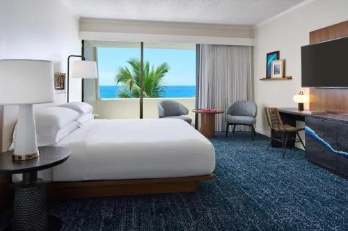 Ocean-view suite bedroom with king bed at Outrigger Kona Resort and Spa.