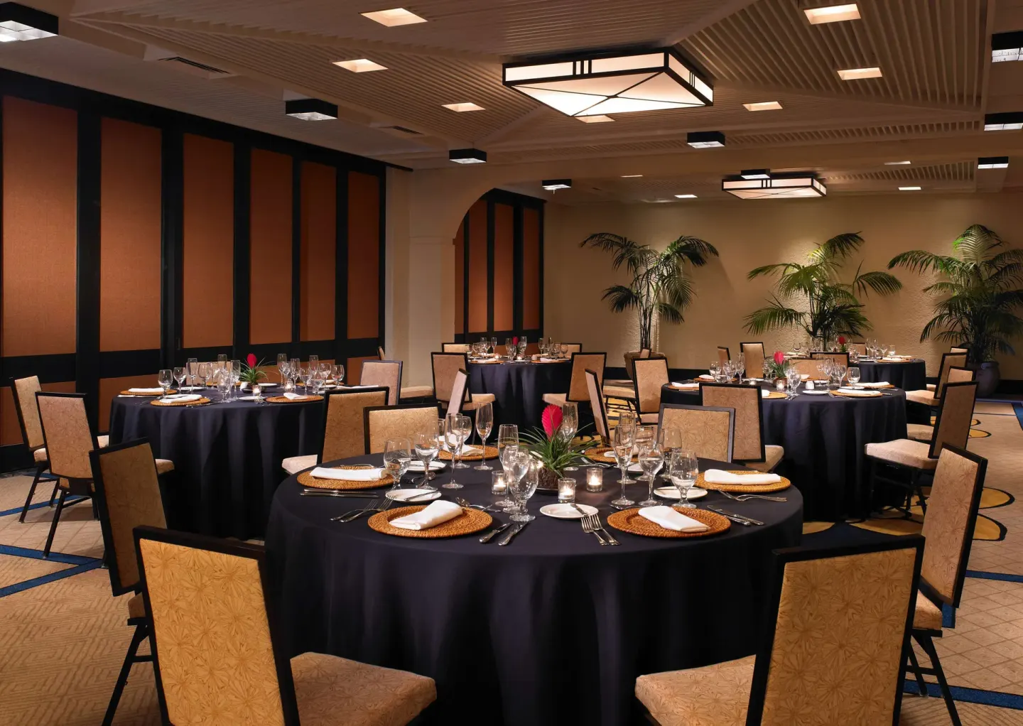 Round banquet tables are set with black linens at Outrigger Kona Resort and Spa.