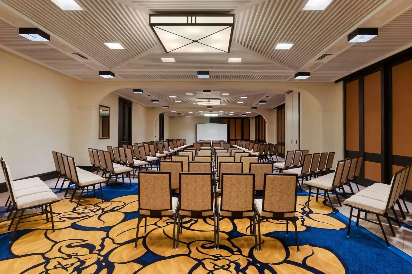 Rows of chairs face a projection screen in a meeting room at Outrigger Kona Resort and Spa.