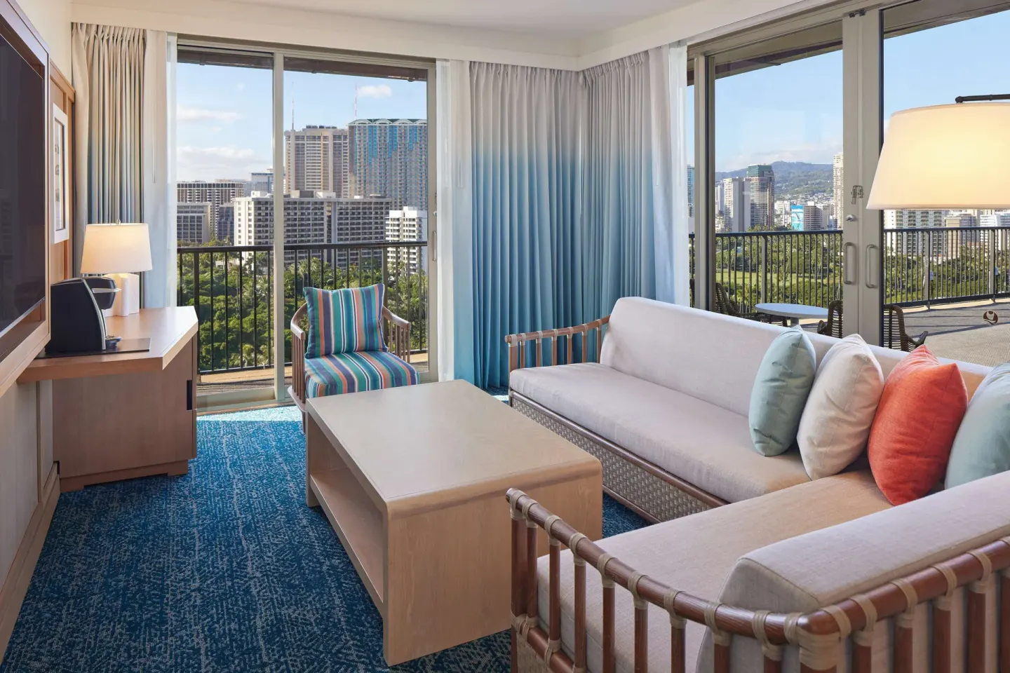 Corner suite living room with sofa and balconies at OUTRIGGER Reef Waikiki Beach Resort.