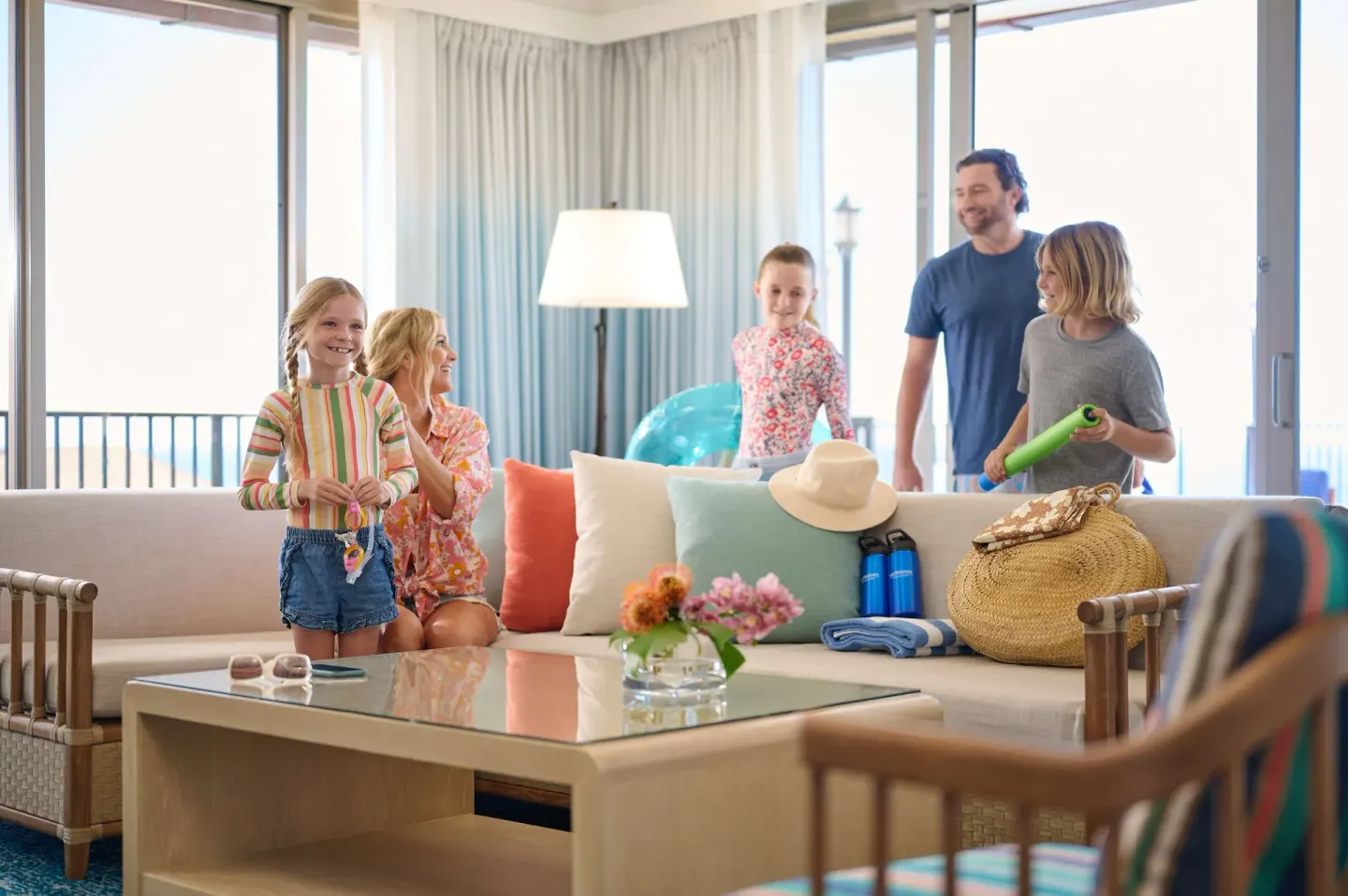 Family in a suite living room with beach items at OUTRIGGER Reef Waikiki Beach Resort.