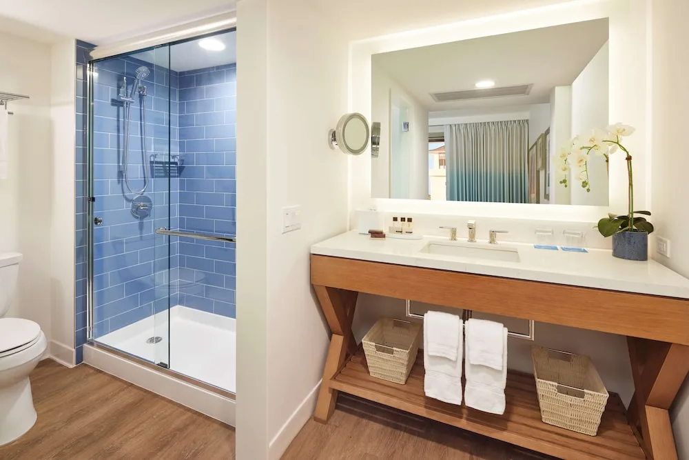 Guest bathroom with glass shower and long vanity at OUTRIGGER Reef Waikiki Beach Resort.