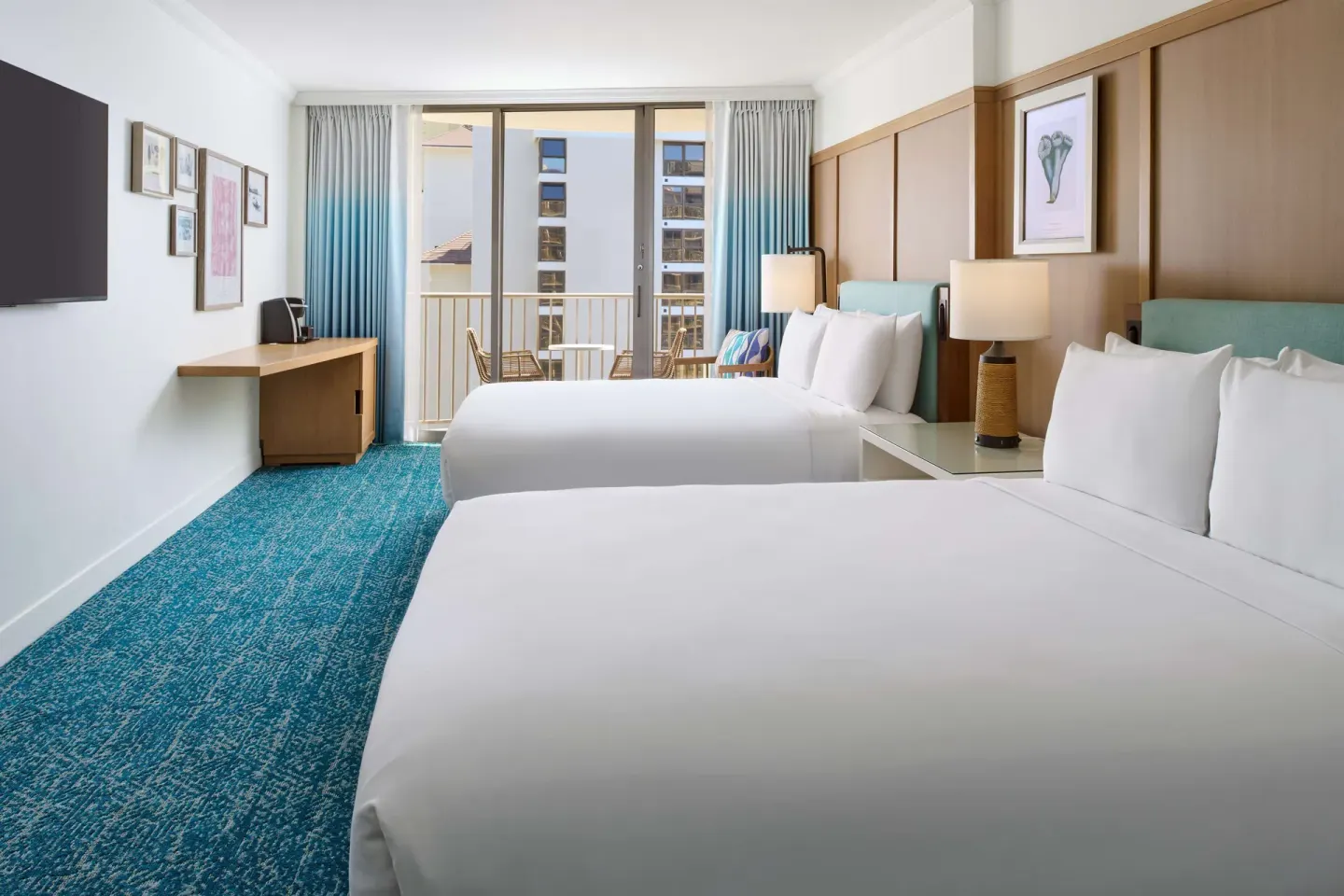 Two-bed guest room with balcony facing nearby buildings at OUTRIGGER Reef Waikiki Beach Resort.
