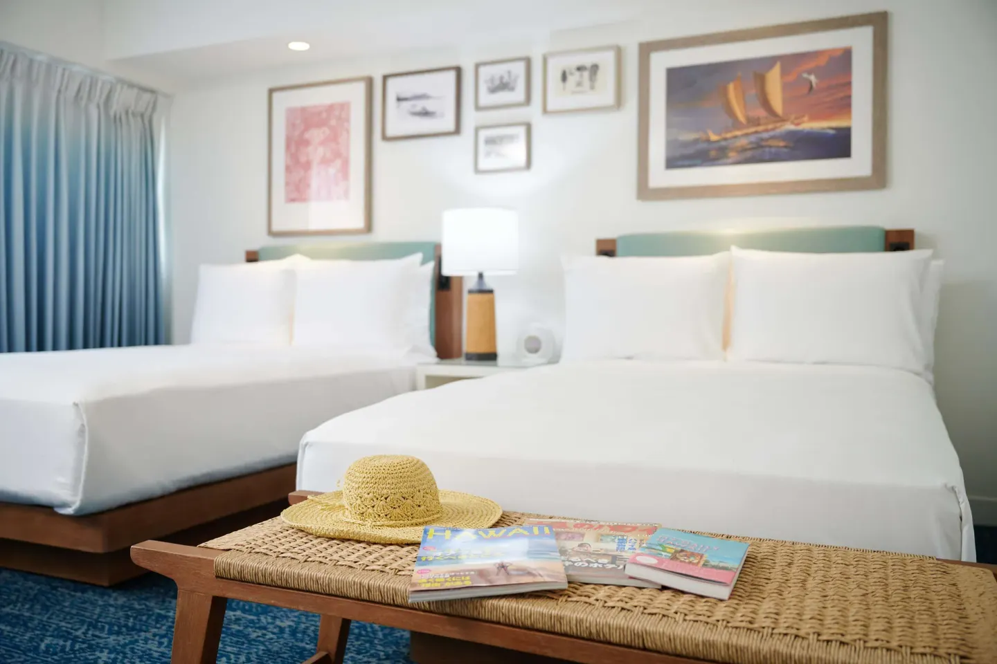 Two-bed guest room with woven bench at OUTRIGGER Reef Waikiki Beach Resort.